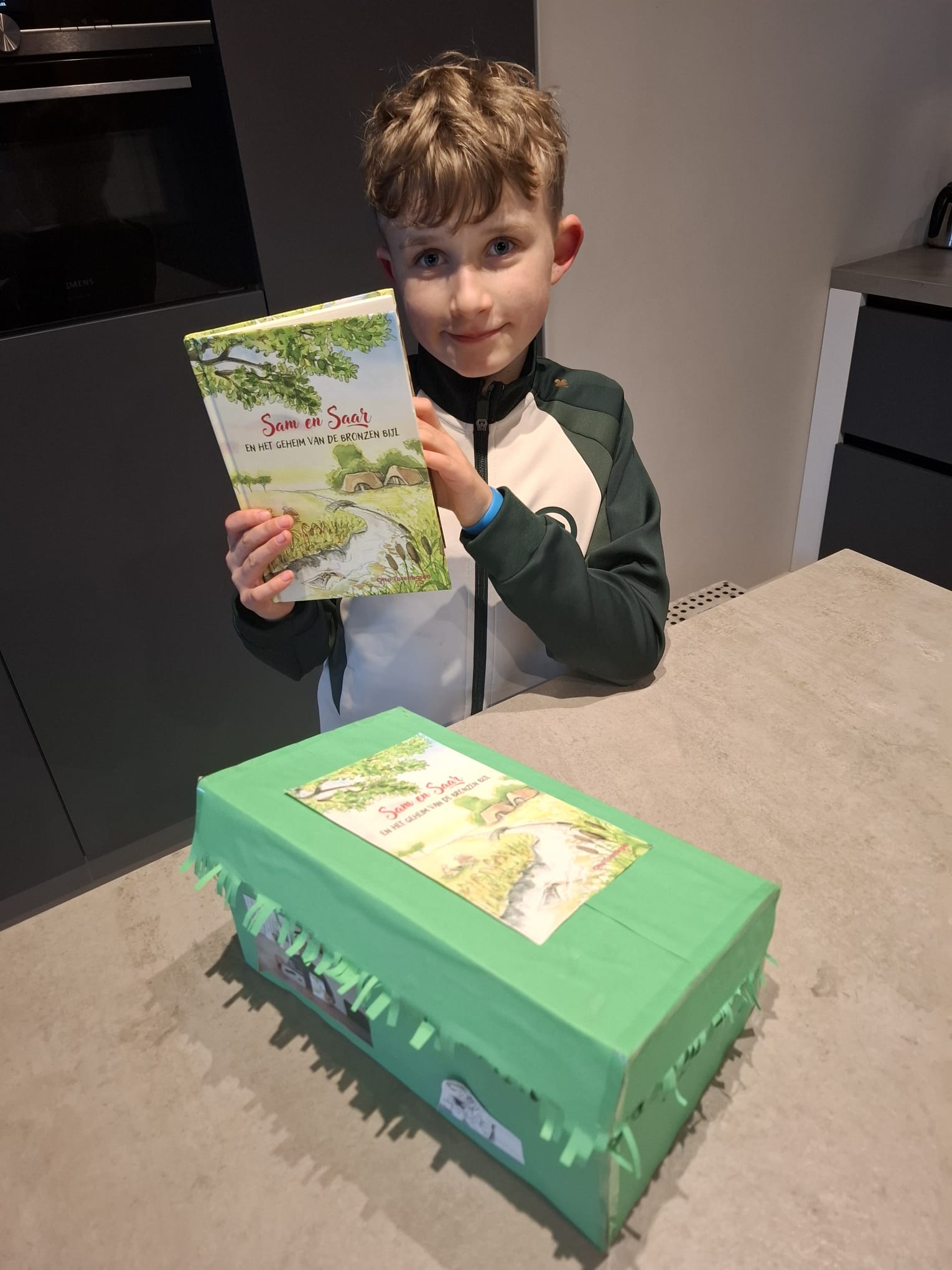 Koen trots met het boek Sam en Saar en zijn zelfgemaakte boekendoos